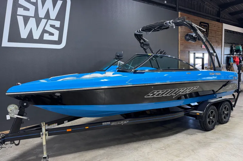 Slide: The Image of 2016 Sanger V237 S boat in showroom, blue and black design, on trailer. - 2