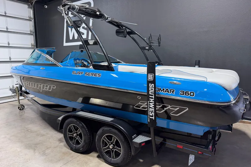 Slide: The Image of 2016 Sanger V237 S boat in blue and black, parked indoors on a trailer. - 3