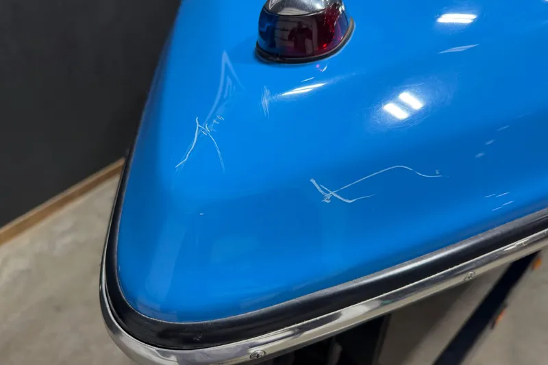 Slide: The Image of Close-up of a 2016 Sanger V237 S boat's blue hull with visible scratches. - 7