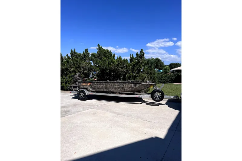 Slide: The Image of 2026 Excel 1854 Shallow Water F4 Pro Hull boat on trailer, outdoors under blue sky. - 1