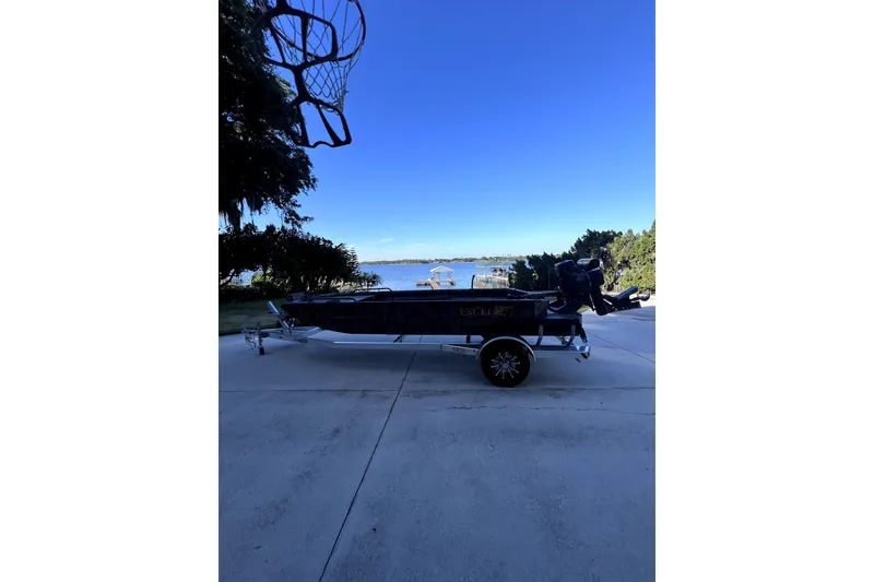 Slide: The Image of 2026 Excel 1854 Shallow Water F4 Pro Hull boat on trailer by lakeside. - 2