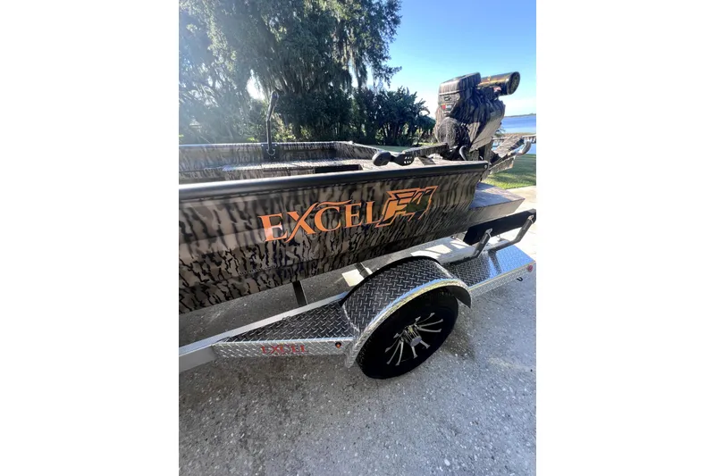 Slide: The Image of 2026 Excel 1854 Shallow Water F4 Pro Hull boat on trailer, outdoors. - 3