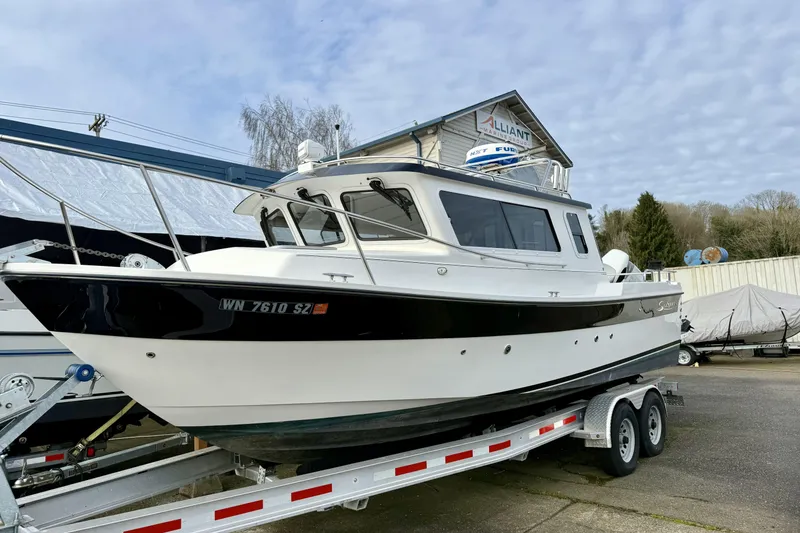 The Image of 2022 Sea Sport 24' Explorer boat on trailer, parked outdoors under cloudy sky. - 0