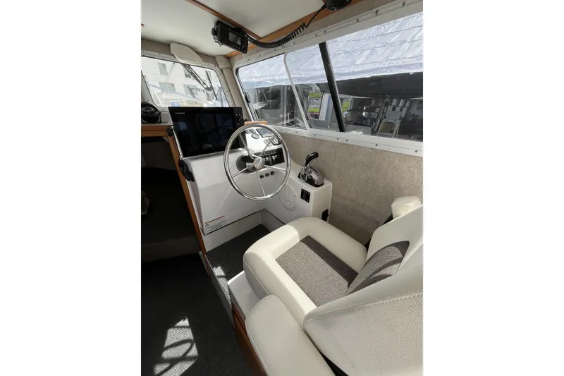 Slide: The Image of Interior of a 2022 Sea Sport 24' Explorer boat, featuring steering wheel and control panel. - 10