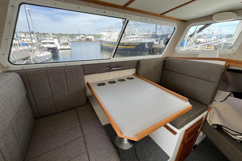 Slide: The Image of Interior of a 2022 Sea Sport 24' Explorer boat with a cozy dining area. - 13