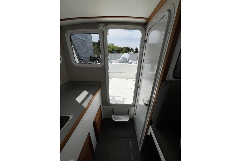 Slide: The Image of Interior view of 2022 Sea Sport 24' Explorer boat, featuring cabin door and windows. - 14