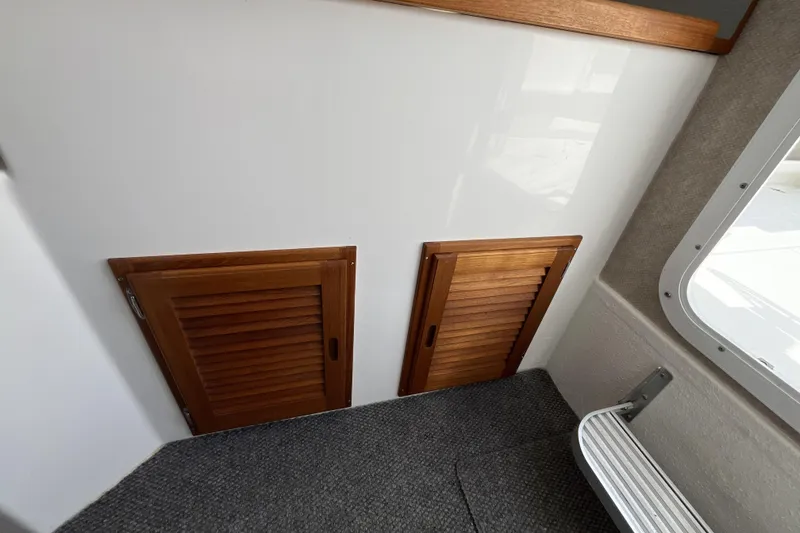 Slide: The Image of Interior of 2022 Sea Sport 24' Explorer with wooden cabinet doors and carpeted flooring. - 18