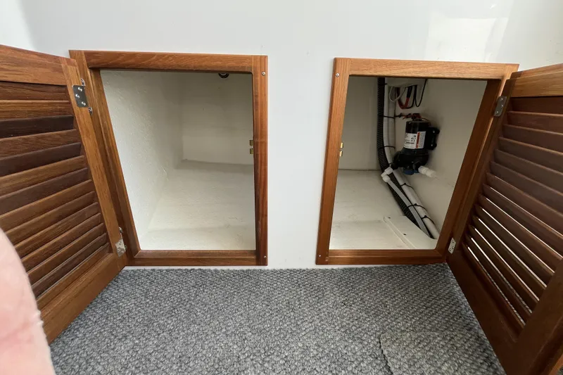 Slide: The Image of Open wooden cabinets in a 2022 Sea Sport 24' Explorer boat interior. - 19