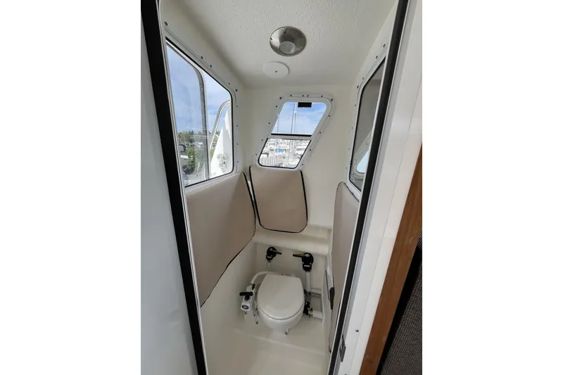 Slide: The Image of Interior of 2022 Sea Sport 24' Explorer boat, featuring compact marine toilet. - 23