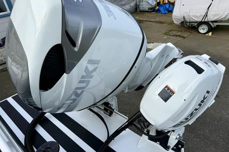Slide: The Image of Suzuki outboard motors on a 2022 Sea Sport 24' Explorer boat, parked on pavement. - 27