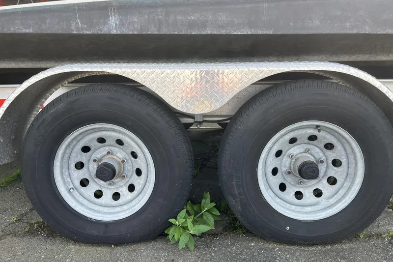 Slide: The Image of Trailer wheels of a 2022 Sea Sport 24' Explorer boat on pavement. - 29