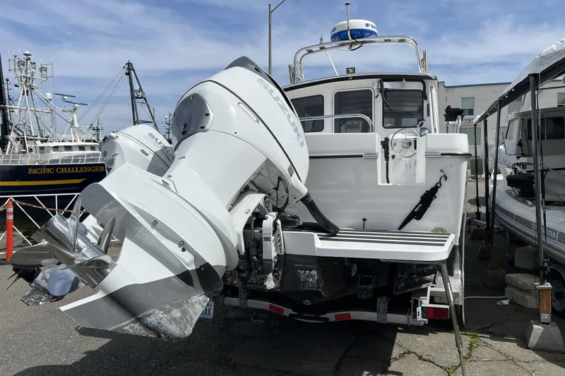 Slide: The Image of 2022 Sea Sport 24' Explorer boat with dual Suzuki outboard motors at a marina. - 7