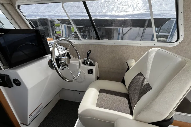 Slide: The Image of Interior of 2022 Sea Sport 24' Explorer boat, featuring helm and captain's chair. - 8