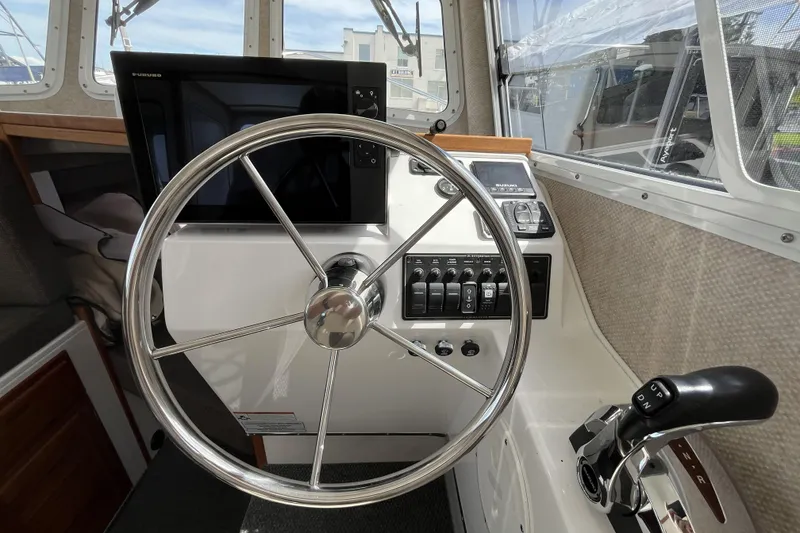 Slide: The Image of Interior helm of 2022 Sea Sport 24' Explorer boat with steering wheel and controls. - 9