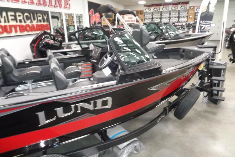 Slide: The Image of 2026 Lund 1875 Pro-V boat in showroom, featuring sleek design and Mercury outboard motor. - 5