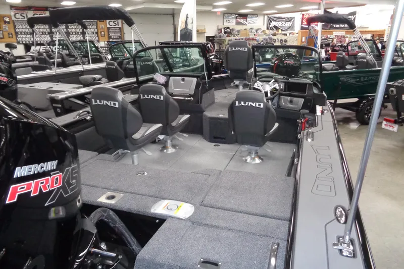 Slide: The Image of 2026 Lund 1875 Pro-V fishing boat interior with Mercury Pro XS engine in showroom. - 6