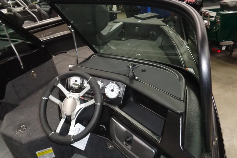 Slide: The Image of 2026 Lund 1875 Pro-V boat interior with steering wheel and dashboard controls. - 8