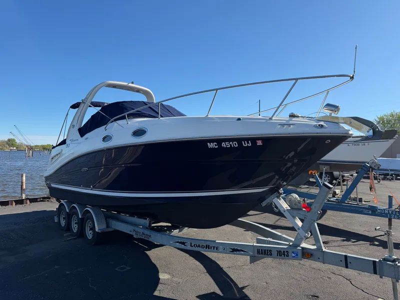 Slide: The Image of 2006 Sea Ray Sundancer 260 on a trailer by the water. - 1