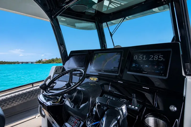 Slide: The Image of Helm of 2022 HCB 42 Lujo boat with advanced navigation displays, steering wheel, and controls. - 7
