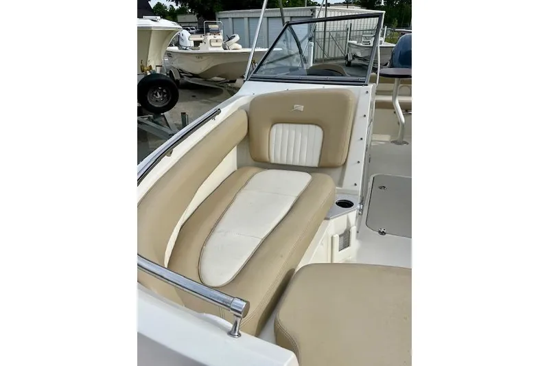 Slide: The Image of 2019 Stingray 201 DS boat interior with beige and white seating. - 10