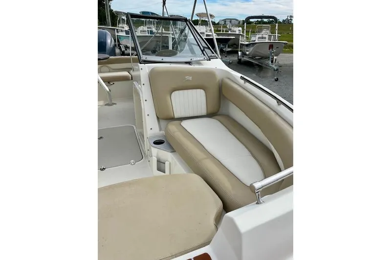 Slide: The Image of 2019 Stingray 201 DS boat interior with beige and white seating. - 11