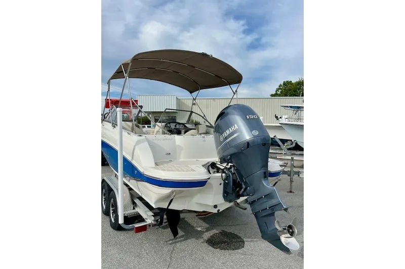 Slide: The Image of 2019 Stingray 201 DS boat with Yamaha outboard motor, parked on a trailer. - 3