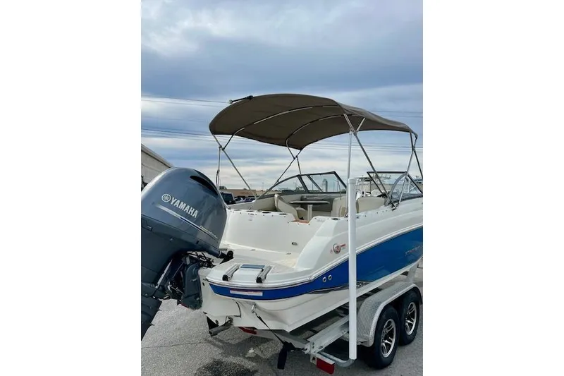 Slide: The Image of 2019 Stingray 201 DS boat with Yamaha outboard motor on trailer, under cloudy sky. - 4