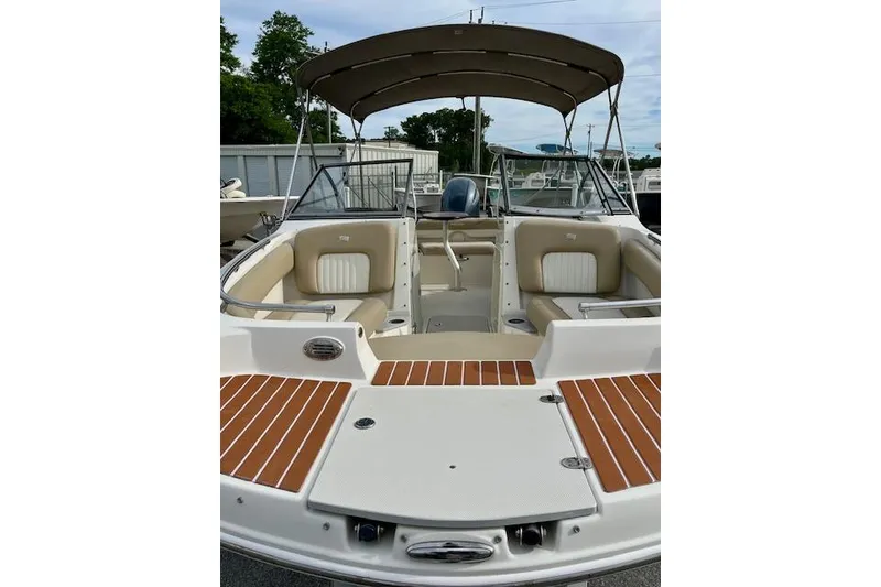 Slide: The Image of 2019 Stingray 201 DS boat with spacious seating and canopy in a marina setting. - 8