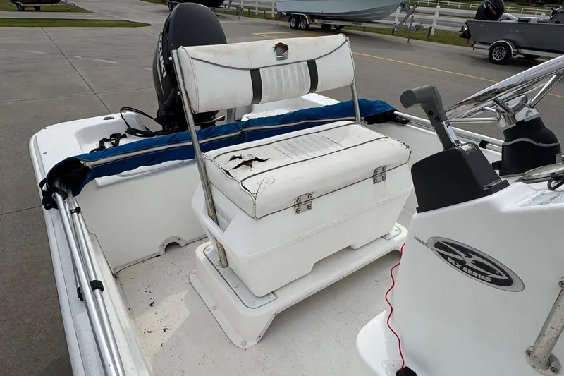 Slide: The Image of 2012 Carolina Skiff 1765 DLX boat interior with worn seating and steering console. - 11