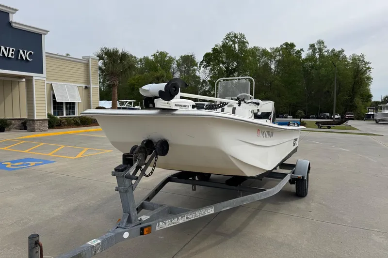 Slide: The Image of 2012 Carolina Skiff 1765 DLX boat on trailer, parked outside a building. - 2