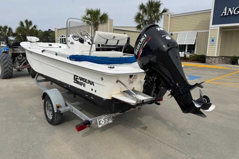 Slide: The Image of 2012 Carolina Skiff 1765 DLX boat on trailer with Suzuki outboard motor. - 3
