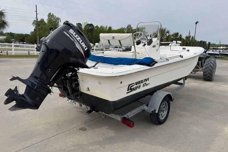 Slide: The Image of 2012 Carolina Skiff 1765 DLX boat with Suzuki outboard motor on trailer. - 5