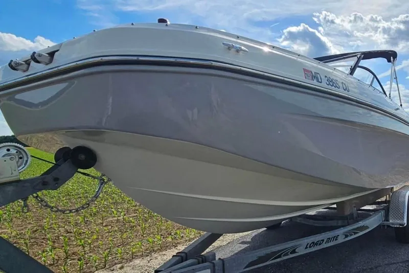 The Image of 2023 Bayliner DX 2200 boat on trailer under a blue sky. - 0