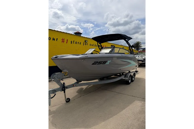 The Image of 2026 Yamaha Boats 255XD on trailer, parked outdoors under cloudy sky. - 0