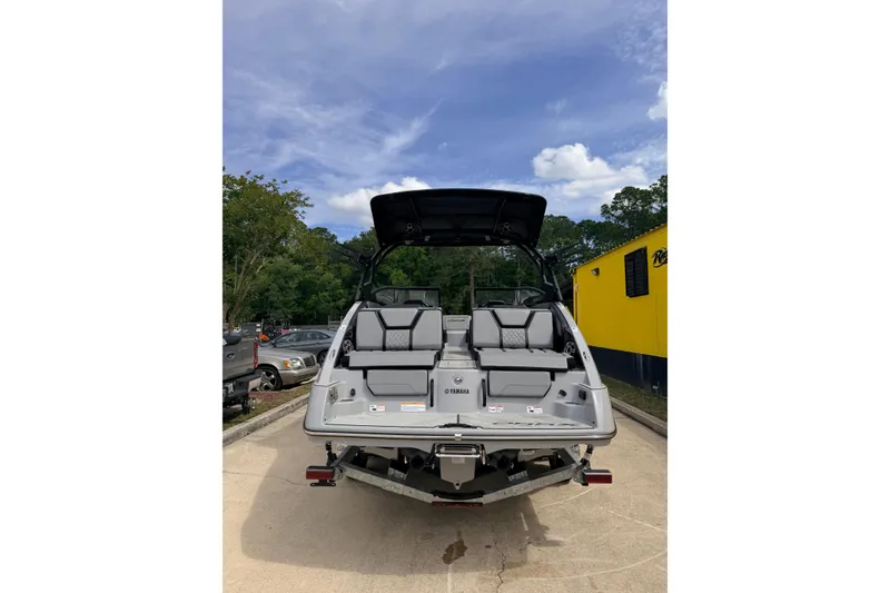Slide: The Image of 2026 Yamaha Boats 255XD, rear view, parked outdoors under a clear sky. - 3
