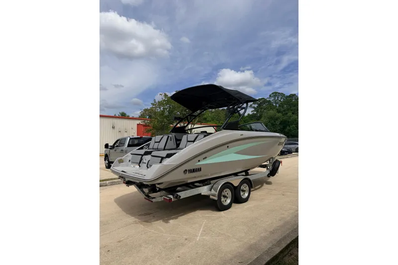Slide: The Image of 2026 Yamaha Boats 255XD on trailer, sleek design, parked outdoors under cloudy sky. - 4