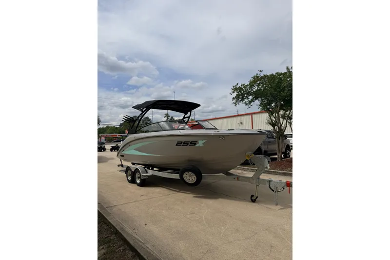 Slide: The Image of 2026 Yamaha Boats 255XD on trailer, parked outdoors under cloudy sky. - 5