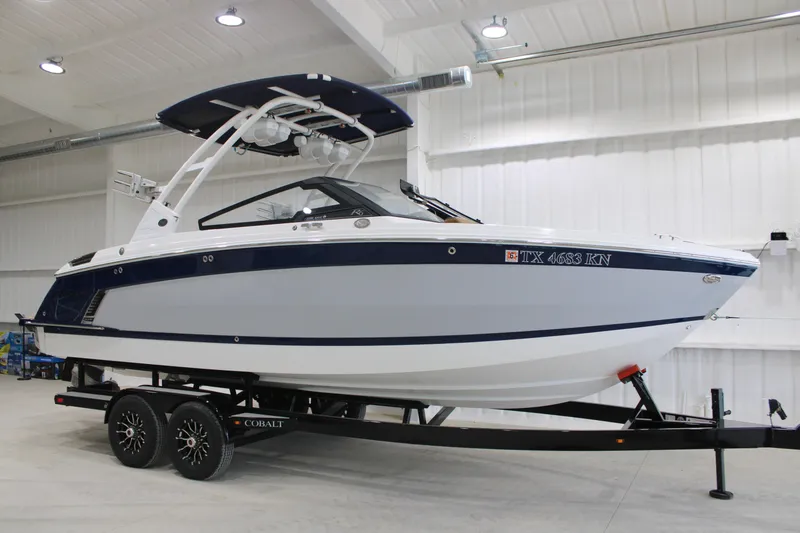 The Image of 2022 Cobalt R6 Surf boat on trailer in indoor showroom. - 0