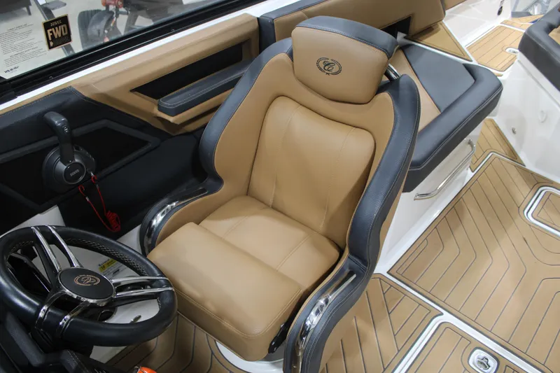 Slide: The Image of 2022 Cobalt R6 Surf boat interior with tan and black captain's seat and steering wheel. - 14