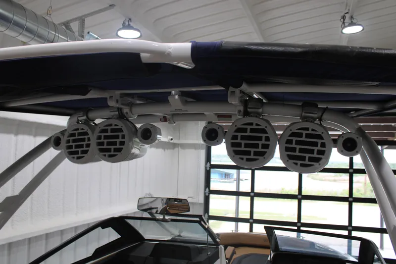 Slide: The Image of 2022 Cobalt R6 Surf boat with mounted speakers in a garage setting. - 20