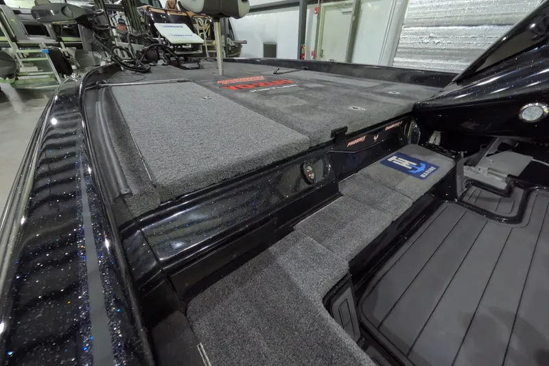 Slide: The Image of 2023 Phoenix 921 Elite boat interior with carpeted deck and storage compartments. - 10