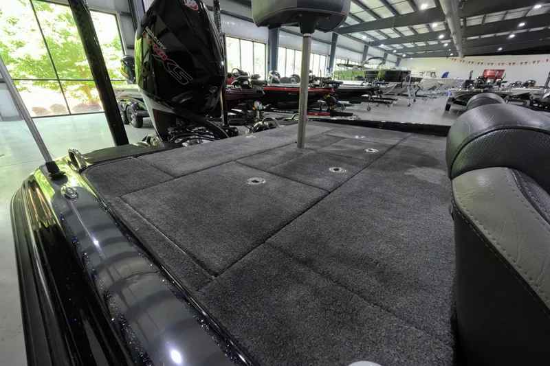 Slide: The Image of 2023 Phoenix 921 Elite boat interior with carpeted deck and seating in showroom. - 4