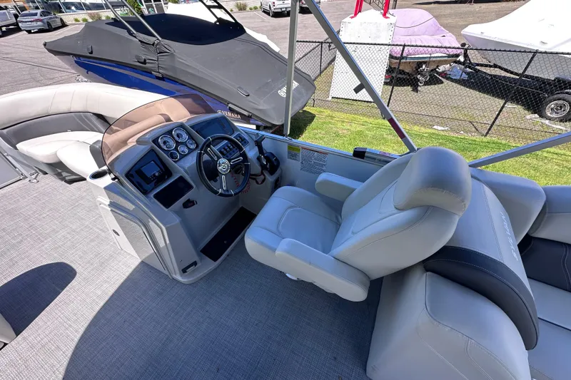 Slide: The Image of 2024 Sylvan Mirage 8522 LZ boat interior with steering console and seating. - 12