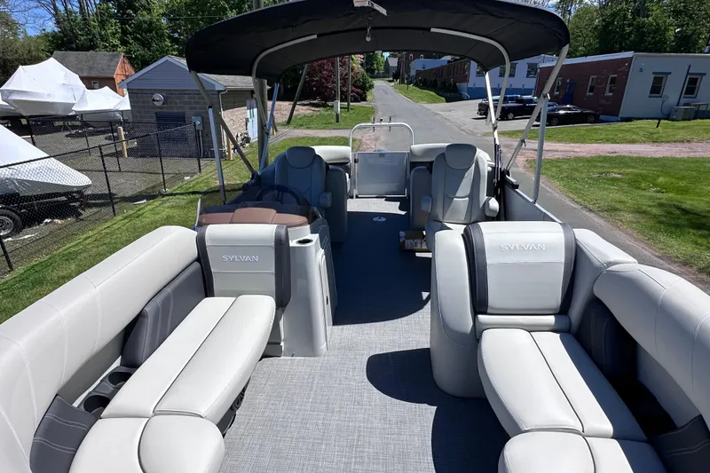 Slide: The Image of 2024 Sylvan Mirage 8522 LZ pontoon boat with spacious seating and canopy, parked outdoors. - 24