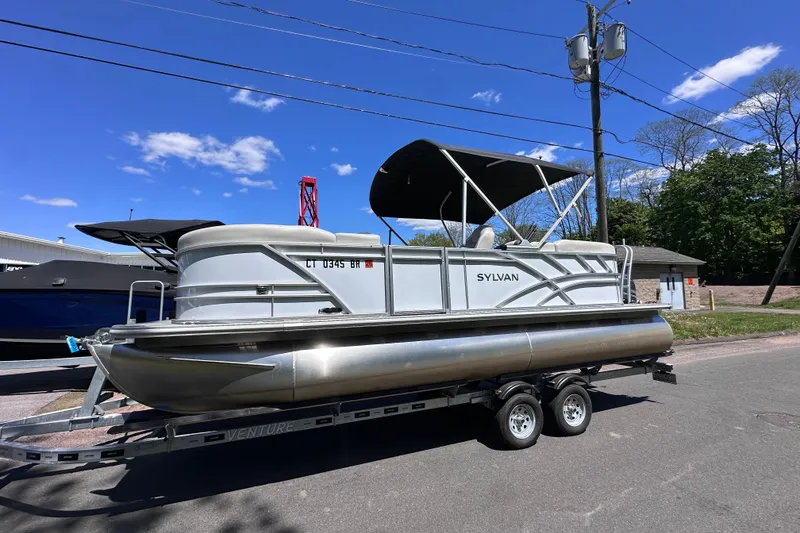 Slide: The Image of 2024 Sylvan Mirage 8522 LZ pontoon boat on trailer under clear blue sky. - 4