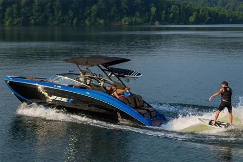 Slide: The Image of 2026 Yamaha Boats 255XD on lake with wakeboarder, surrounded by lush greenery. - 14