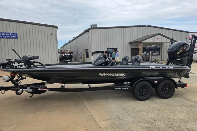 The Image of 2026 Phoenix 921 Elite X boat on trailer outside service center. - 1