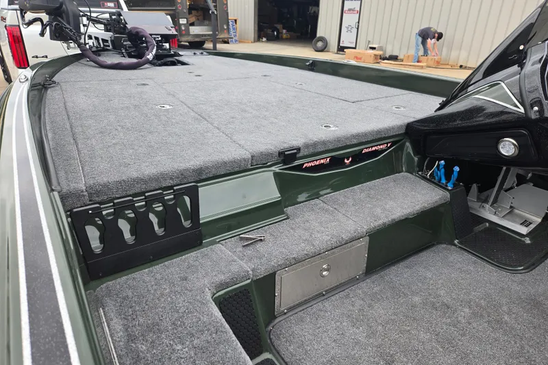 Slide: The Image of 2026 Phoenix 921 Elite X boat interior with carpeted deck and storage compartments. - 23