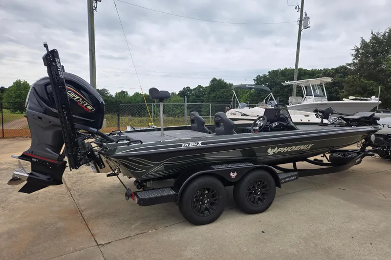Slide: The Image of 2026 Phoenix 921 Elite X boat on trailer, parked outdoors, showcasing sleek design and powerful engine. - 3