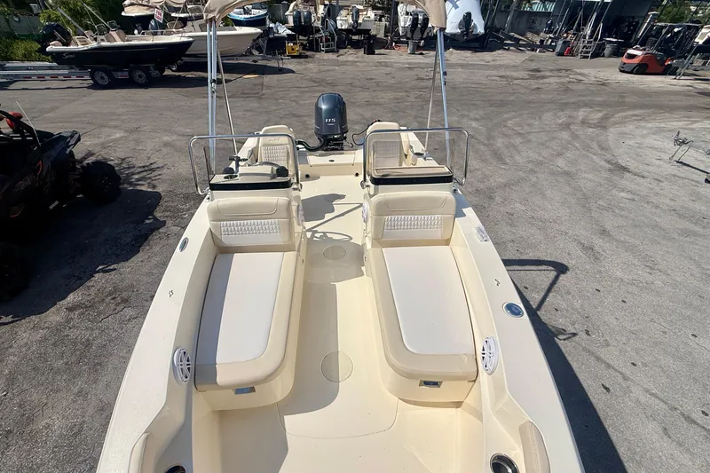 Slide: The Image of 2026 Scout 188 Sport Dorado boat with dual seating and outboard motor in a marina. - 10